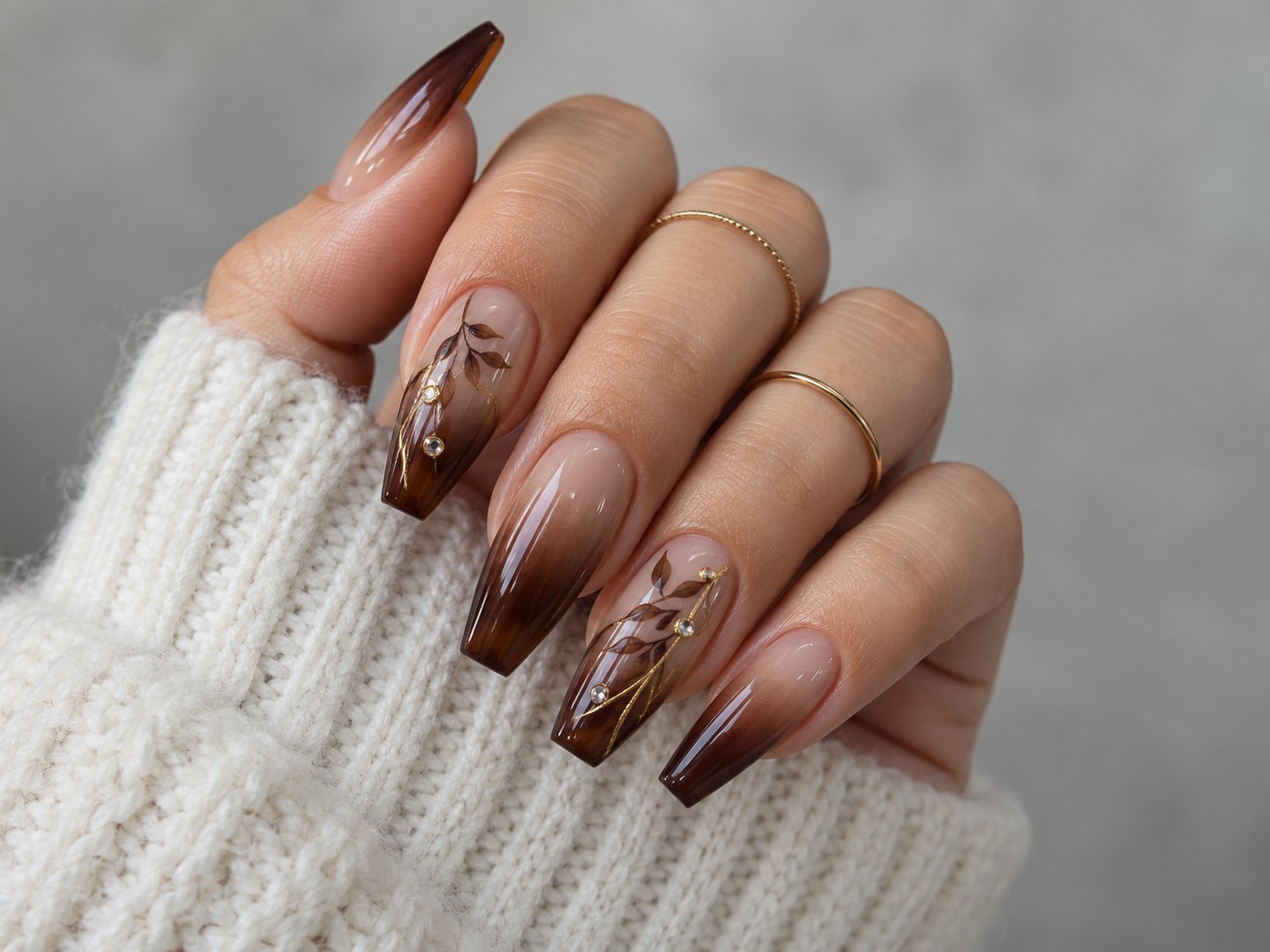 Unhas bailarina em ombré do nude ao chocolate, com folhas pintadas à mão e strass